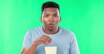 Green screen, face and black man eating popcorn while watching movie, film or cinema on mockup background. Tv, portrait and male with snack while enjoying streaming, subscription or entertainment