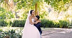 Love, wedding and husband carrying his wife outdoor in a garden on their marriage day celebration or ceremony. Happy, smile and a married couple in a park with a groom lifting his bride in tradition