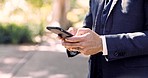 Phone, hands and closeup of businessman in nature typing a text message or networking on social media. Technology, outdoor and professional male browsing on the internet with a cellphone in a park.