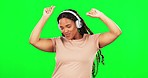 Green screen, happy woman and dancing to music in studio, freedom and celebration. Dance, female model and headphones for listening to audio, streaming and sound of radio, relax and rhythm of energy