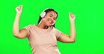 Green screen, woman and dance to music with smile in studio, freedom and fun celebration. Headphones, happy female model and dancing to audio, streaming sound and listening to radio in energetic mood