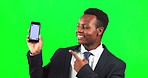 Cellphone, mock up and male in studio with green screen pointing at space for advertising or marketing. Happy, portrait and African man model showing mockup on phone isolated by chroma key background