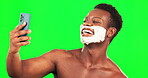 Selfie, shaving and perfect with a black man on a green screen background in studio for grooming to skincare. Phone, shave and hand gesture with a handsome young male in the bathroom for beauty