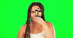 Woman cover face with makeup brushes on green screen, aesthetic change or facial. Portrait, female model and collection of beauty tools, cosmetics and skincare for transformation, facelift or glamour