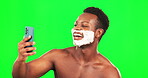 Selfie, shaving and pout with a black man on a green screen background in studio for grooming to skincare. Phone, shave and lips kiss expression with a handsome young male in the bathroom for beauty