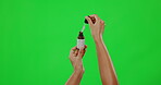 Hands, beauty and woman with serum on green screen, liquid and skincare with moisturizer on studio background. Bottle, mockup and dropper for healthy skin with cosmetic care product and dermatology