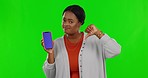 Black woman, phone and thumbs down by green screen, studio and face with bad review for app, website or service. Female, hand sign and feedback mockup with smartphone, disappointment and opinion