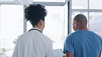 Healthcare, doctor and nurse walking, talking and checking schedule or patient chart with advice. Hospital, back of man and woman with clipboard in lobby, planning and consultation in clinic together