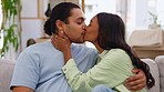 Kiss, love and couple relax on sofa at home for bonding, commitment and show affection on weekend. Dating, interracial relationship Indian woman and man together for embrace, intimacy and romance