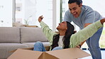 Moving in, box and a homeowner couple playing together in the living room of their new home with excitement. Property, love or happy with a playful man and woman having fun while bonding in a house 