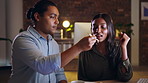 Sushi, date and a man feeding his girlfriend while sitting in the dining room of their home together at night. Food, eating and love with a couple enjoying a romantic evening of bonding in a house