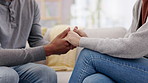 Hands, trust and empathy with a couple on a sofa in the living room for their home for support, love or care. Help, compassion or comfort with a man and woman consoling during pain, loss or grief