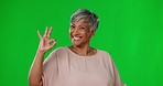 Smile, green screen and okay hand gesture, portrait of woman on studio background with mock up and positive opinion. Happy mature model, ok sign language and happiness with agreement on poll or vote.