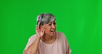 Listening, hear and senior woman on green screen with hand gesture for deaf, hearing problem and whisper. Communication, quiet and female asking for loud talking, speaking and cupping ear in studio