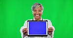 Woman, doctor and tablet on green screen with tracking markers against a studio background. Portrait of happy senior female medical expert showing touchscreen display for online Telehealth on mockup