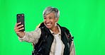 Selfie, happy and a woman backpacking on a green screen isolated on a studio background. Smile, travel and an elderly lady taking photos while hiking for memories and social media on a backdrop