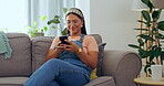 Asian woman, phone and relax on living room sofa for social media, texting or communication at home. Happy female relaxing on lounge couch browsing, scrolling or chatting on mobile smartphone indoors