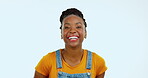 Portrait, funny and humor with a black woman in studio on a blue background laughing at a joke. Face, comedy and comic with an attractive young female joking or enjoying laughter and carefree fun