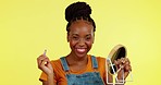 Face, skincare and black woman with mirror, makeup and foundation against a studio background. Portrait, African American female and girl with cosmetics tools, application and wellness with smile