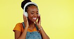 Happy, dance and a black woman with headphones for music isolated on a yellow background in studio. Smile, enjoying and an African girl listening to audio, radio or favorite songs while dancing