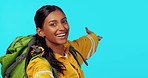 Wave, video call and a woman hiking with space isolated on a blue background in studio. Happy, talking and face portrait of a girl greeting and showing mockup for the internet backpacking on backdrop