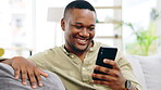 Black man, phone and smile on sofa for social media, communication or networking in living room at home. Happy African American male relaxing on couch with mobile smartphone for browsing or chatting