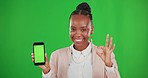 Green screen, okay sign and black woman with phone point for advertising, branding and logo mockup. Happy, studio space and portrait of girl on smartphone for mobile app, website and social media
