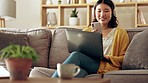 Laptop, phone and Asian woman relax with headphones listening to music, streaming song and audio. Remote work, home and happy girl in living room sofa on smartphone for social media, chat and texting