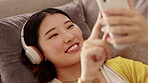 Phone, relax or girl in headphones typing on social media reading online content on gossip blog at home. Mobile app, smile or happy Asian woman texting messages on internet or network website to chat