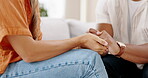 Closeup, couple and holding hands to forgive, love and care with empathy at home. Life partner, helping hand and support of mental health, hope and kindness of healing, depression and comfort anxiety