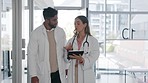Healthcare walking or doctors with tablet, information or discussion in hospital for surgery. Medical professionals, coworkers or surgeons share schedule, results or advice for procedure or diagnosis
