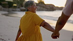 Happy woman, walking and holding hands at beach of couple on holiday, freedom and relax from behind. Retirement, senior people and quality time at sea for love, care and laughing on travel vacation