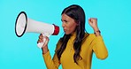 Woman, megaphone and protest shouting in studio for equality or economic change against a blue background. Angry female activist protesting on big microphone screaming for voice or empowerment