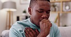 Sick, cough and man on a sofa in the living room in recovery from covid, flu or cold at his house. Healthcare, illness and African male with a chest infection, allergies or throat problem in his home