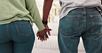 Love, care and couple holding hands together in a home or house in a closeup back view in an apartment. Romantic, man and woman leaving for a date spending quality time in a lounge for support