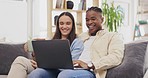 Laptop, coffee and couple talking in living room on home sofa, relax or online shopping. Computer, interracial and happiness of man and woman on couch internet browsing, social media or web scrolling