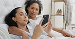 Phone, bed and couple of friends relax with social media post, mobile application or reading internet blog at home. Young gen z woman or lesbian people talking of lgbtq, planning or chat in bedroom