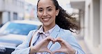 Happy, face and a woman with heart hands in the city for love, support and review. Smile, carefree and portrait of a girl in business smiling with a gesture for positivity, care and happiness