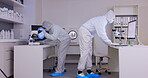 Medical, laboratory and scientist team research vaccine or sample using a microscope and computer with hazmat suit. Virus, teamwork and scientist working on an experiment in partnership in a lab