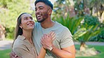 Park, date and happy couple holding hands with love and a smile outdoor on summer day. Happiness, nature and embrace of a man and woman together for holiday and romance laughing from garden fun