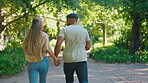 Love, date and couple running in a park together feeling happy in nature and bonding in happiness outdoors. People, man and woman playing enjoying freedom and romance in a forest in summer