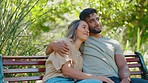 Park, relax and happy interracial couple on bench for bonding, quality time and calm on weekend date. Relationship, dating and man and woman hug, embrace and kiss for trust, commitment and romance