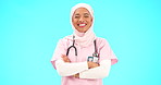 Muslim woman, face and nurse smile with arms crossed in studio isolated on blue background mockup. Portrait, medical professional and confident, happy and proud Islamic person or surgeon from Turkey.