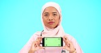 Muslim woman, phone and no for green screen portrait with mockup, website or review. Islamic female with smartphone and shaking head for healthcare app or bad feedback or rating on blue background 