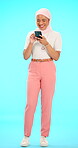 Phone, laughing and Muslim woman reading in studio isolated on blue background mockup. Cellphone, social media and Islamic person watching funny meme, comedy or comic joke, online browsing or texting