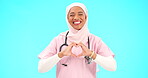 Face, nurse and Muslim woman with heart hands in studio isolated on a blue background mockup. Smile, portrait and happy medical professional or Islamic person with emoji or symbol for love and care.