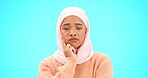 Muslim woman, thinking and idea with hand on face for mockup, advertising or thought. Serious islamic female with hijab and emoji for doubt, sad and to think about option on a studio blue background