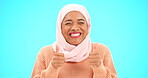 Muslim woman, happy and thumbs up portrait in studio for mockup, advertising or promotion. Islamic female with hand emoji, smile and hijab excited for announcement or sale on blue background