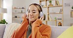 Headphones, sofa and happy woman listening to music for mental health, youth radio and streaming at home. Young asian person or relax with audio technology in living room, couch or apartment for Kpop