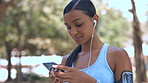 Music earphones, phone and fitness woman outdoor, text messaging or social media on break. Cellphone, sports and Indian athlete listening or streaming audio, radio or podcast before workout or run.